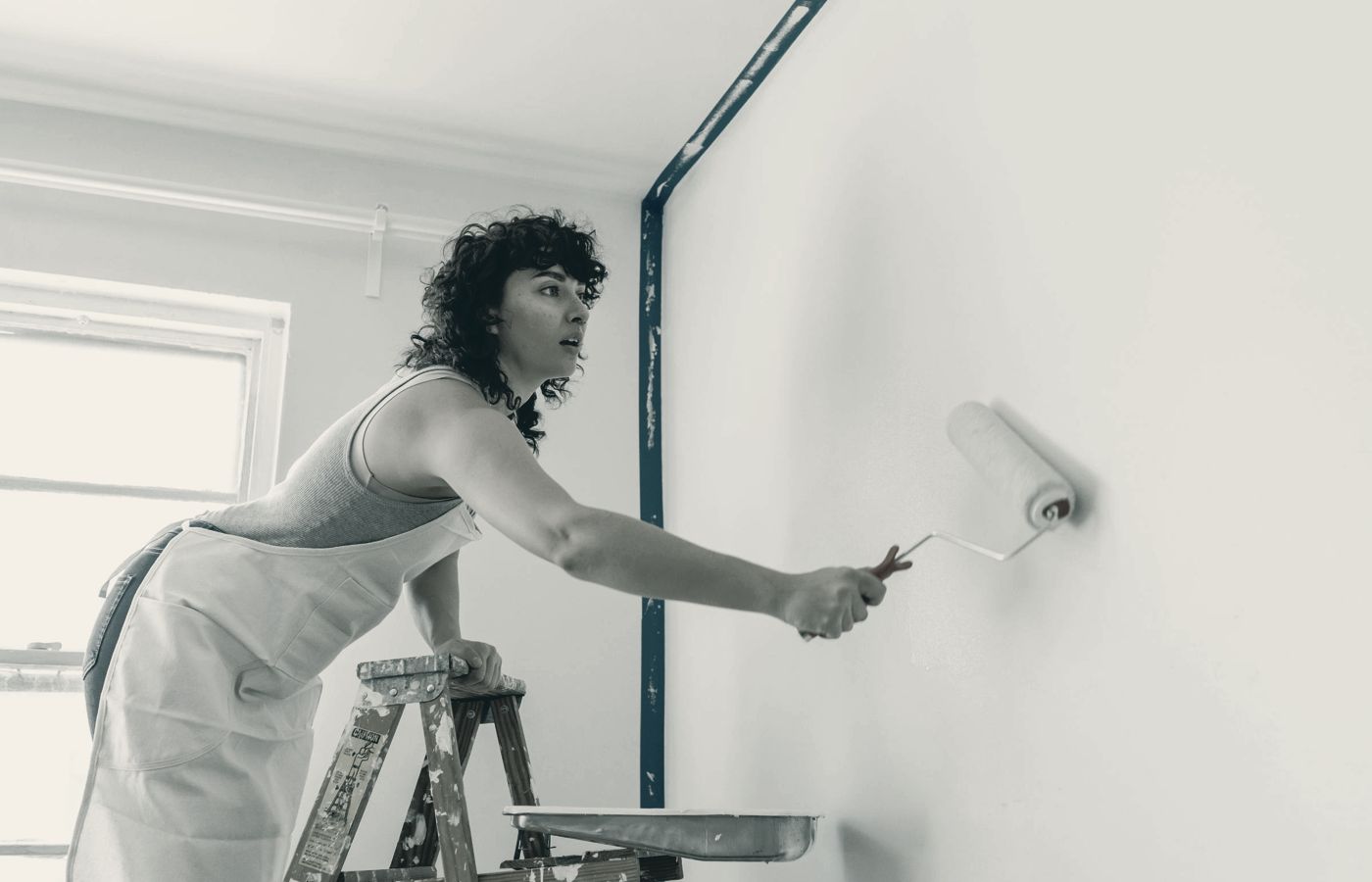 Schilder op een trap rolt een muur